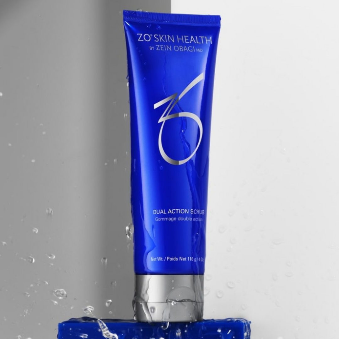Blue tube of ZO Skin Health Dual Action Scrub with water splashes on a blue surface