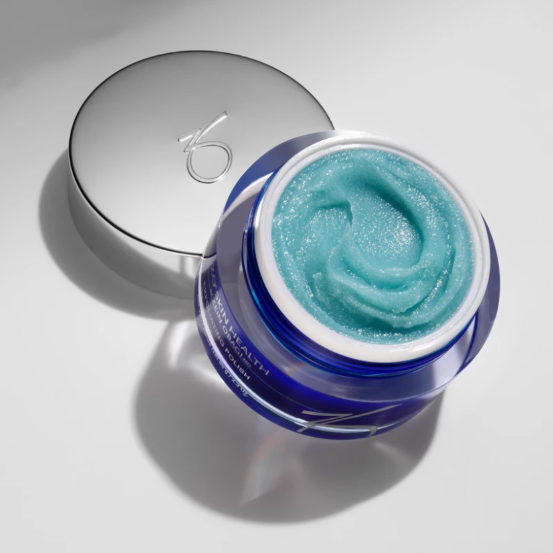 Open jar of blue exfoliating polish cream with silver lid on white background