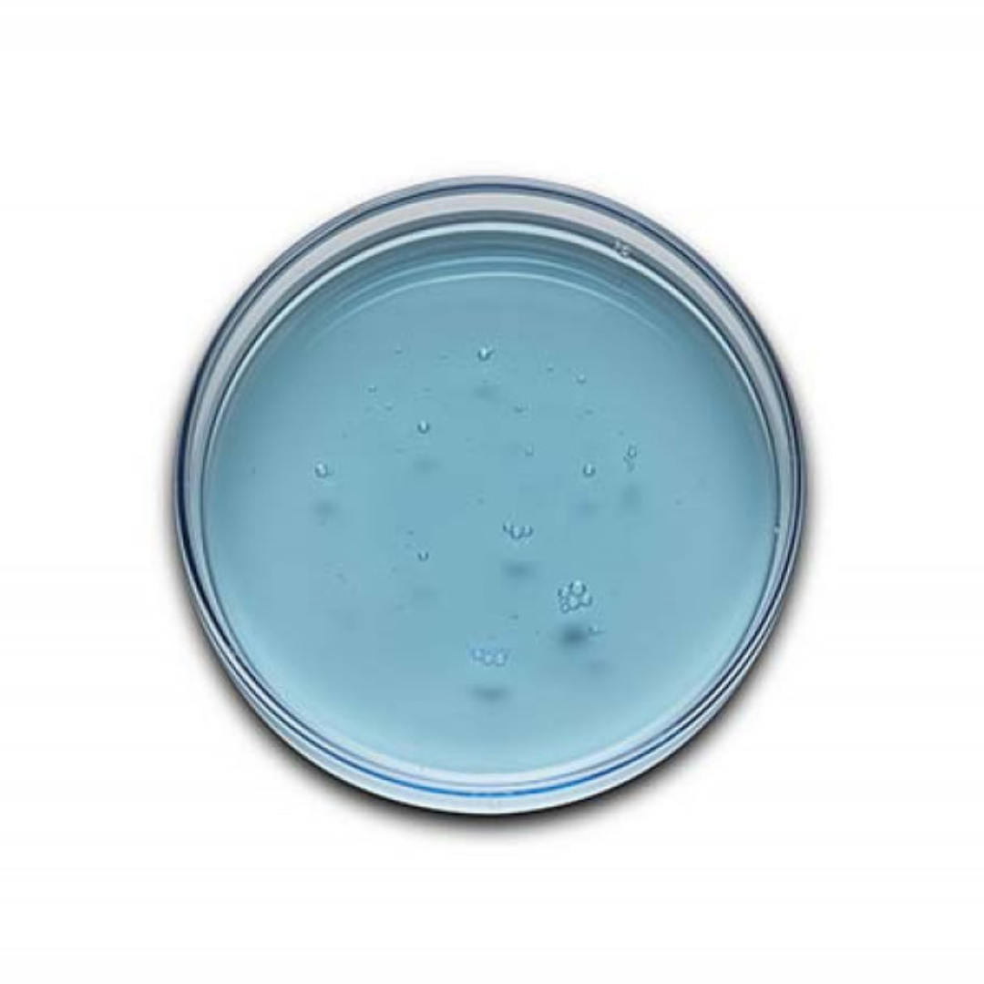 Top view of transparent blue gel cleanser in clear round container on white background