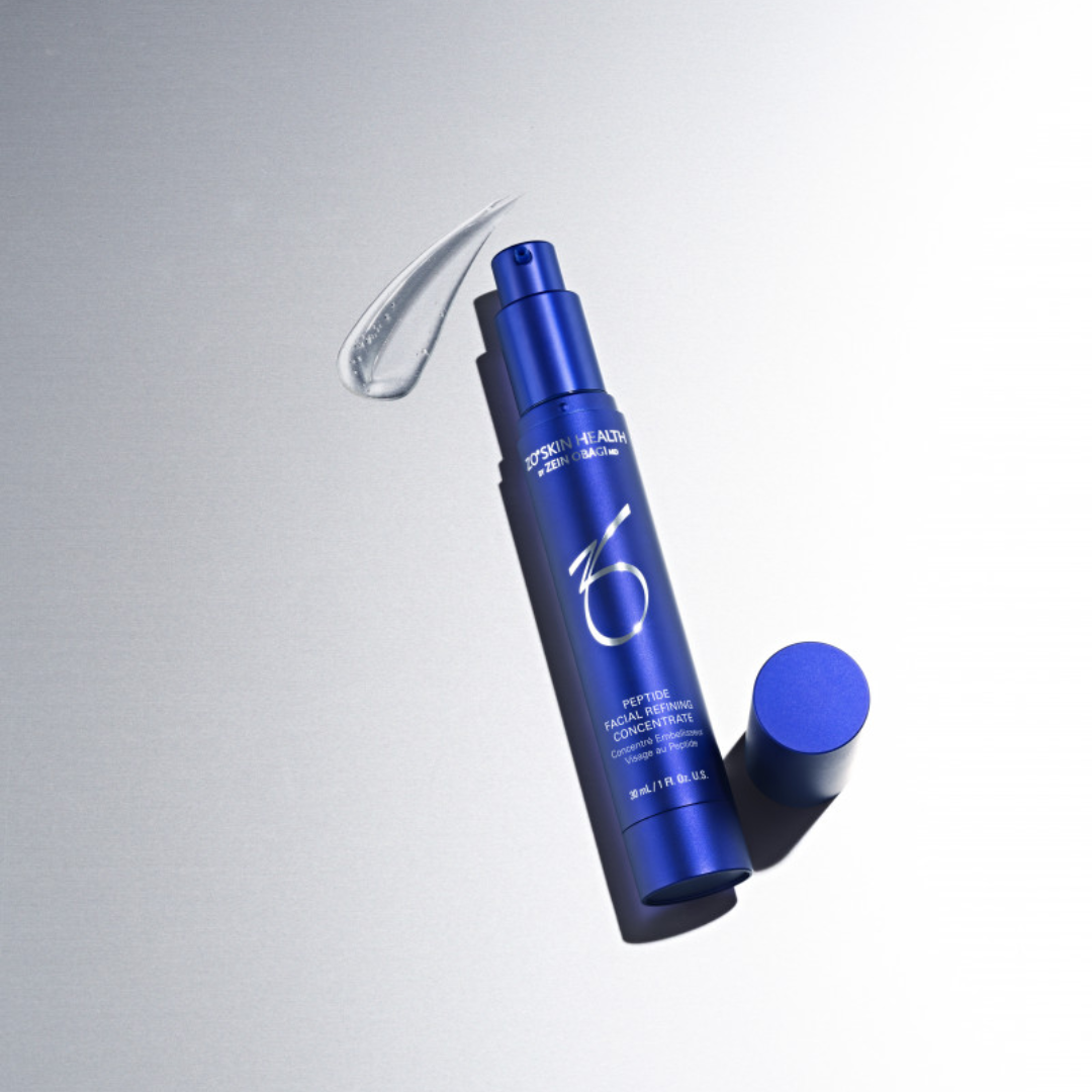 Blue bottle of ZO Skin Health Peptide Facial Refining Concentrate with clear serum on silver background