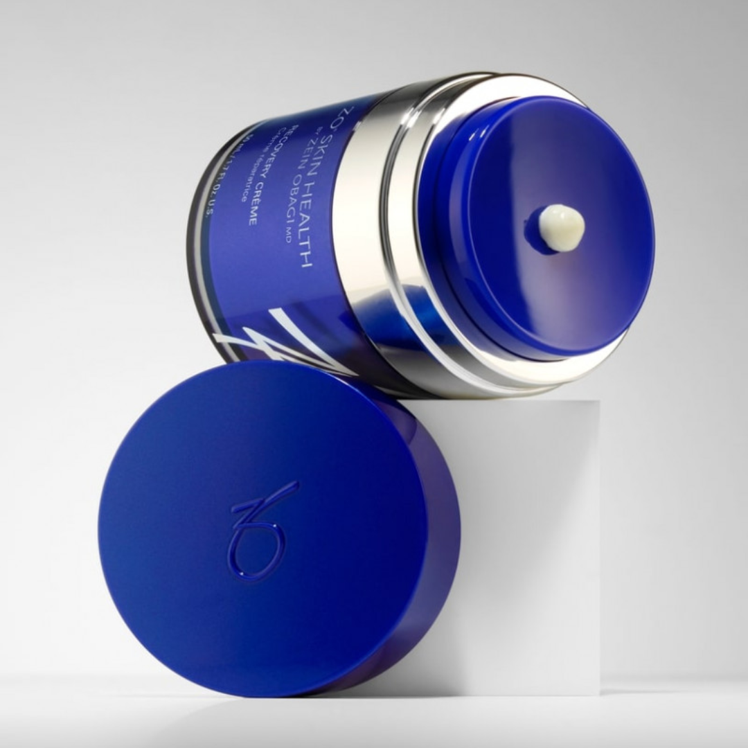 Blue jar of Zo Skin Health Recovery Crème on white cube with cream on lid