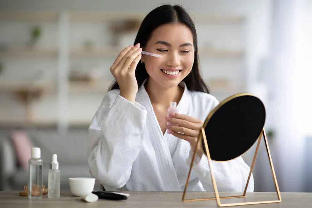 Woman applying facial serum at home as part of a daily skincare routine